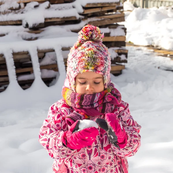 Vackra lilla flicka som leker i snön — Stockfoto