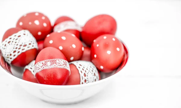 Красные пасхальные яйца на белой тарелке — стоковое фото