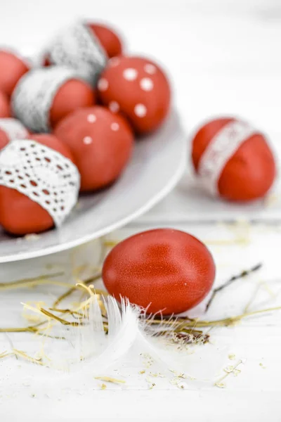 Красные пасхальные яйца на белой тарелке — стоковое фото