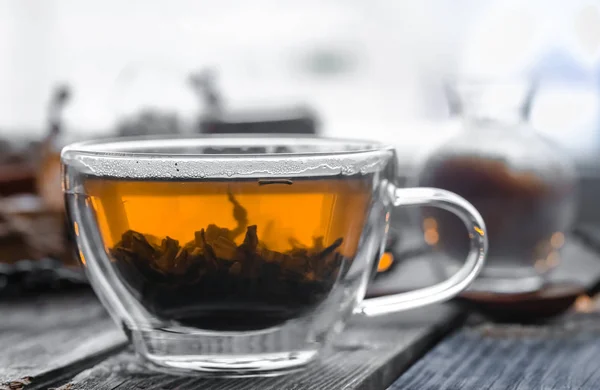 Διαφανές φλιτζάνι τσάι σε φόντο ξύλινη — Φωτογραφία Αρχείου