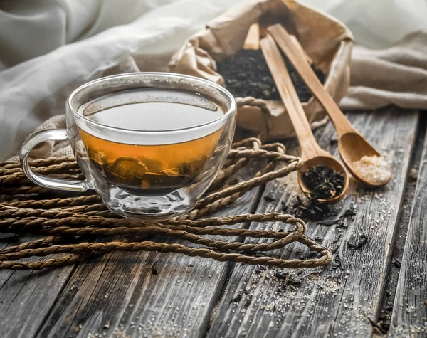 Νεκρή φύση με διαφανές φλιτζάνι τσάι σε φόντο ξύλινη — Φωτογραφία Αρχείου