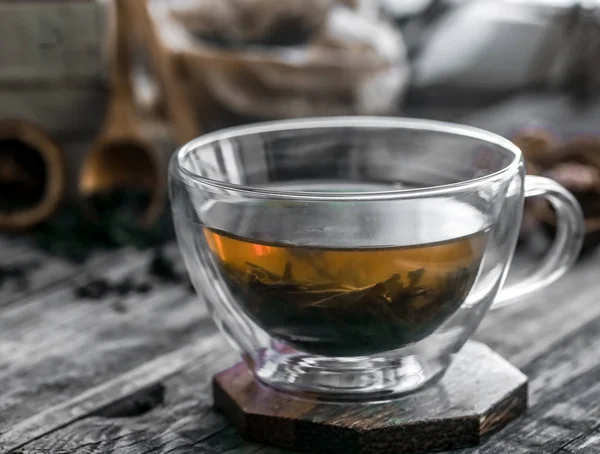 Διαφανές φλιτζάνι τσάι στέκεται στο ξύλινο πλαίσιο — Φωτογραφία Αρχείου