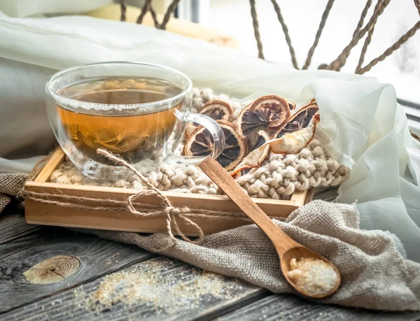 Натюрморт с прозрачной чашкой чая на деревянном фоне — стоковое фото