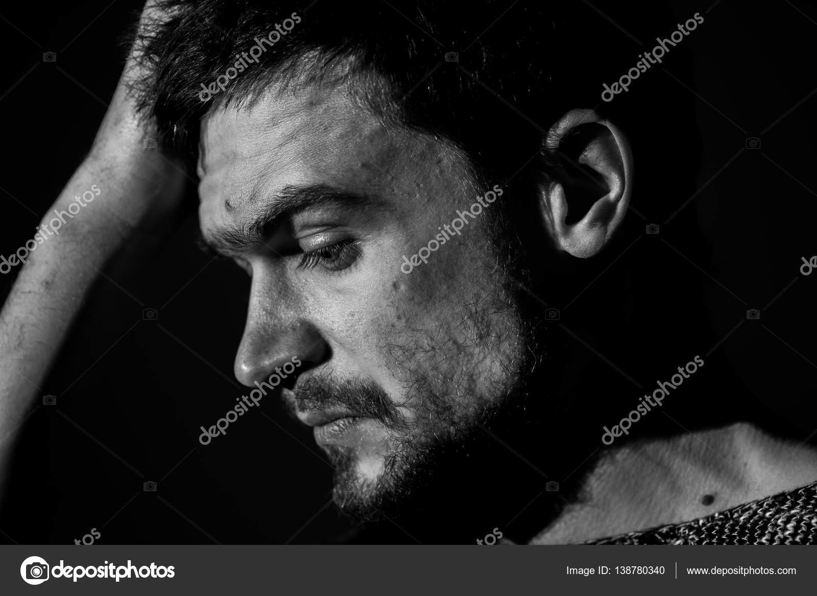 Sad young man on a dark background sad emotions black and white photography close up photo by puhimec