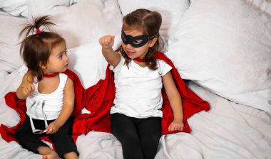 süper kahraman oynayan iki küçük kız