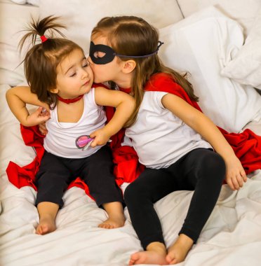 süper kahraman oynayan iki küçük kız