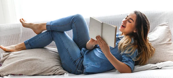 Λευκό άνετο κρεβάτι και μια όμορφη κοπέλα, διαβάζοντας ένα βιβλίο, οι έννοιες του σπιτιού και άνεση — Φωτογραφία Αρχείου