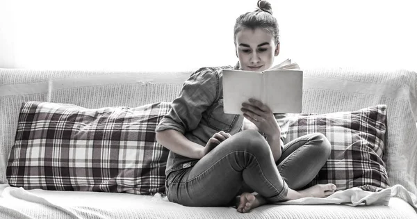 Λευκό άνετο κρεβάτι και μια όμορφη κοπέλα, διαβάζοντας ένα βιβλίο, οι έννοιες του σπιτιού και άνεση — Φωτογραφία Αρχείου