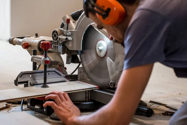 A man working with a miter saw — Stock Photo, Image