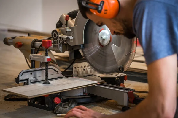 A man working with a miter saw — Stock Photo, Image