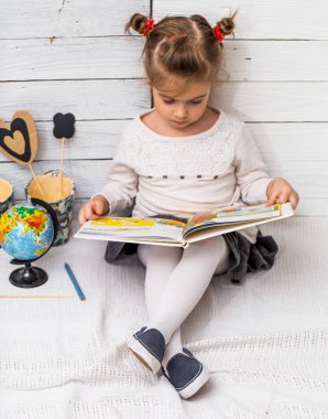 liseli kız küre elleri ve dizüstü bulunan beyaz ahşap zemin üzerinde oturur