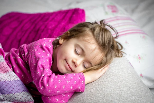Küçük kız pembe bir yatakta uyumak — Stok fotoğraf