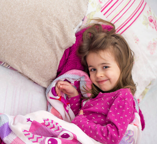 little girl sleeping in a pink bed