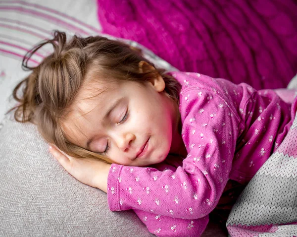 Little girl sleeping in a pink bed — Stock Photo, Image