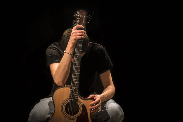 Siyah arka plan üzerine akustik gitar ile genç adam — Stok fotoğraf