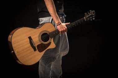 siyah arka plan üzerine akustik gitar ile genç adam