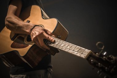 siyah arka plan üzerine akustik gitar ile genç adam