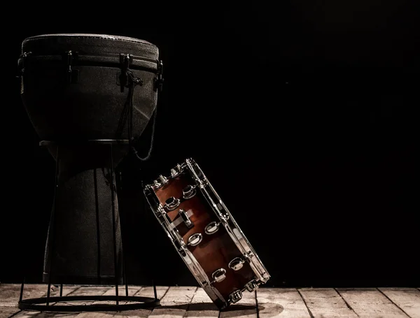 musical percussion instruments on black background drum Bongo and snare