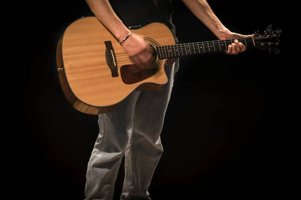 Jeune homme avec guitare acoustique sur fond noir — Photo