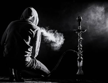 a man smokes a hookah on a black background, beautiful lighting clipart