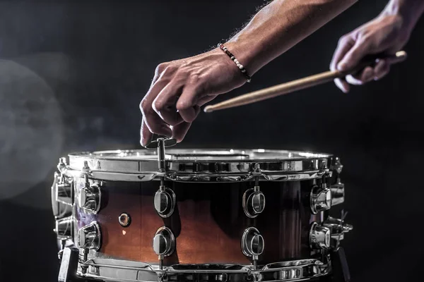 Homem ajusta um instrumento de percussão, conceito musical com o tambor de trabalho — Fotografia de Stock