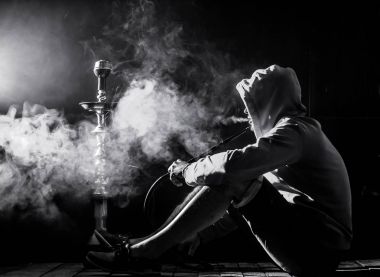 a man smokes a hookah on a black background, beautiful lighting clipart