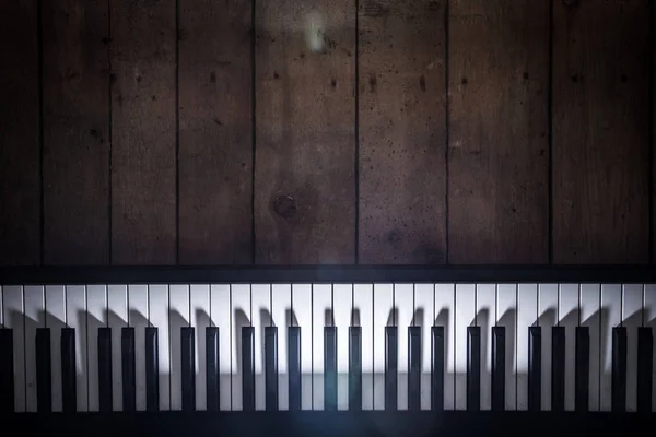 Piano on wooden background closeup — Stock Photo, Image