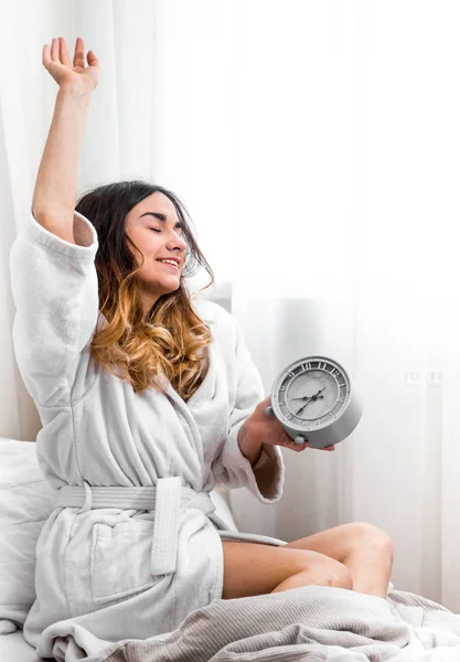 Chica en la mañana en la cama con reloj —  Fotos de Stock