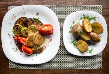 ahşap bir masa üzerinde bir tabak içinde et ızgara sebze