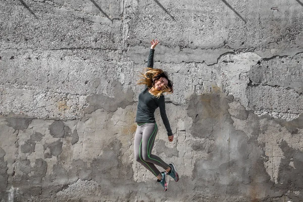 Fitness-Mädchen in Sportkleidung an der Wand Hintergrund — Stockfoto
