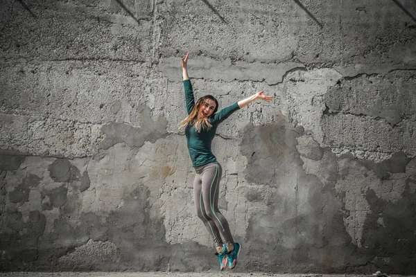 Fitness tjej i sportkläder på vägg bakgrund — Stockfoto