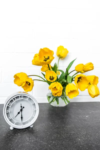 Ramo de tulipanes amarillos y un reloj retro —  Fotos de Stock