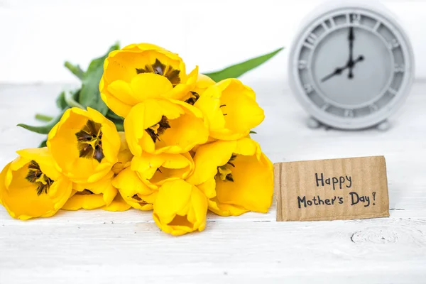 Kytice žlutých tulipánů a retro hodiny — Stock fotografie