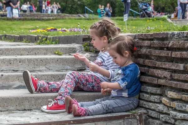 Две маленькие девочки, сидящие на ступеньках — стоковое фото