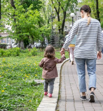 küçük bir kız anne ile el ele gider