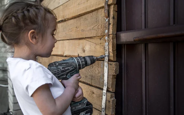 Niña con destornillador en las manos —  Fotos de Stock