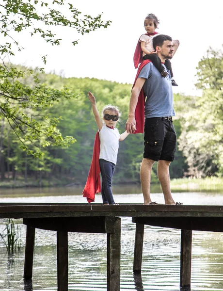 Papá con dos hijas, interpreta a un súper héroe — Foto de Stock