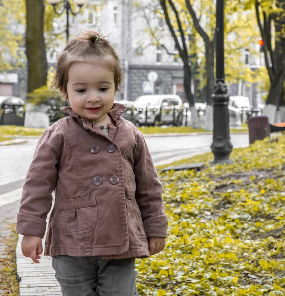 Маленькая девочка в пальто ходит по улице — стоковое фото