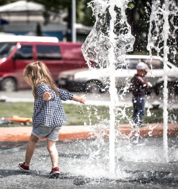 Küçük kız fıskiyede oynamak