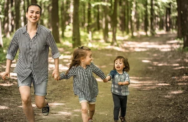 Madre con hijas jóvenes caminan en el bosque —  Fotos de Stock