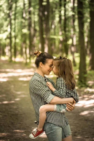 Madre e hija joven caminan en el bosque — Foto de Stock
