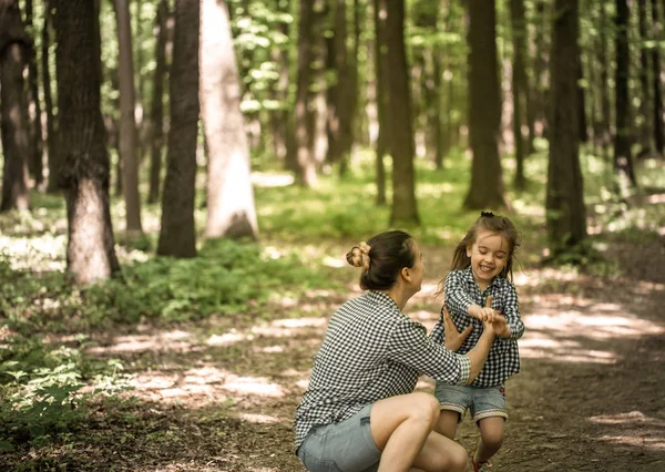 Madre con hijas jóvenes caminan en el bosque — Foto de Stock