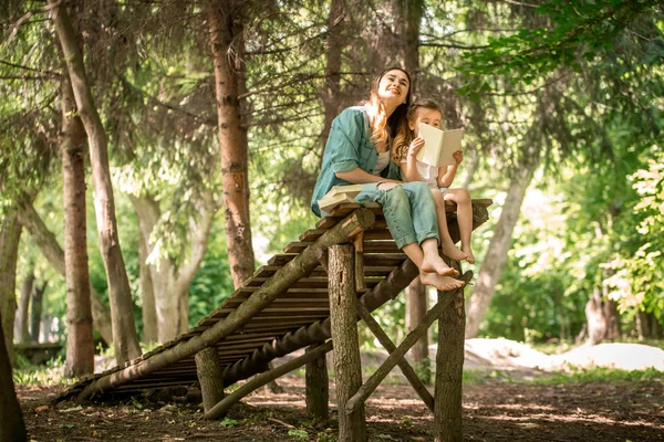 Mutter und Tochter lesen im Park ein Buch — Stockfoto