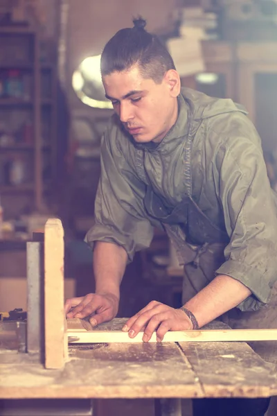Un hombre trabaja en la máquina con el producto de madera — Foto de Stock