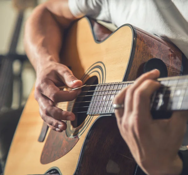 O cara tocando guitarra acústica — Fotografia de Stock