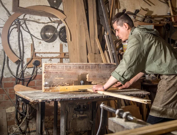 Un hombre trabaja en la máquina con el producto de madera — Foto de Stock