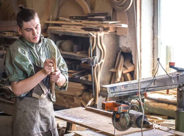 Un uomo lavora sulla macchina con il prodotto in legno — Foto Stock