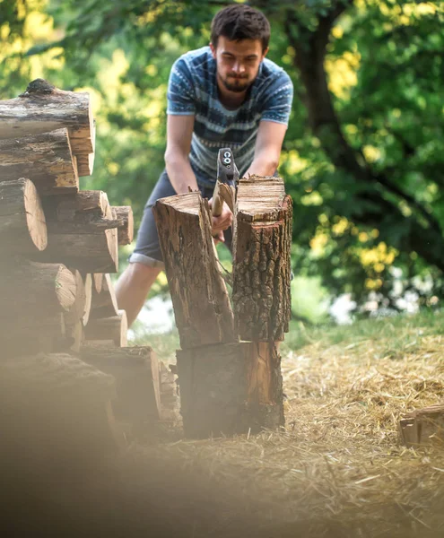 Man hugger ved med en yxa — Stockfoto