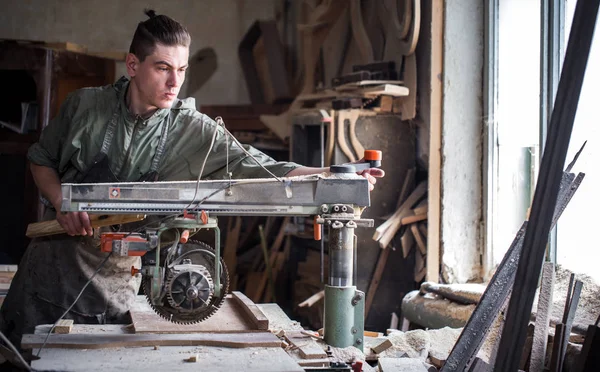 Un hombre trabaja en la máquina con el producto de madera — Foto de Stock