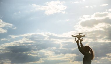 güzel kız bir alanda dron gökyüzüne başlattı.